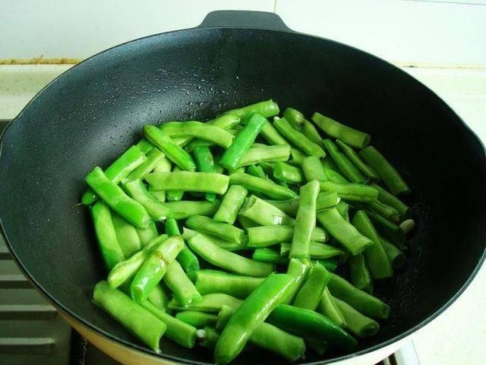 家庭厨房中正在翻炒无筋豆的场景