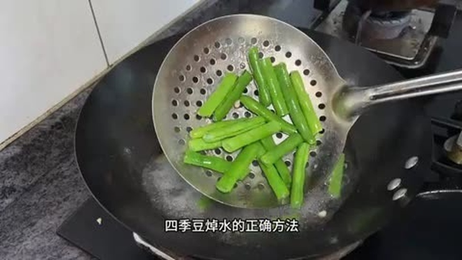 一位家庭主妇正在厨房操作台前将切好的四季豆倒入沸水中焯烫,旁边放置生豆和熟豆对比样本,墙上挂有‘豆类必须煮熟’的安全提示牌,突出家庭场景下的正确处理方式 家庭厨房安全操作场景