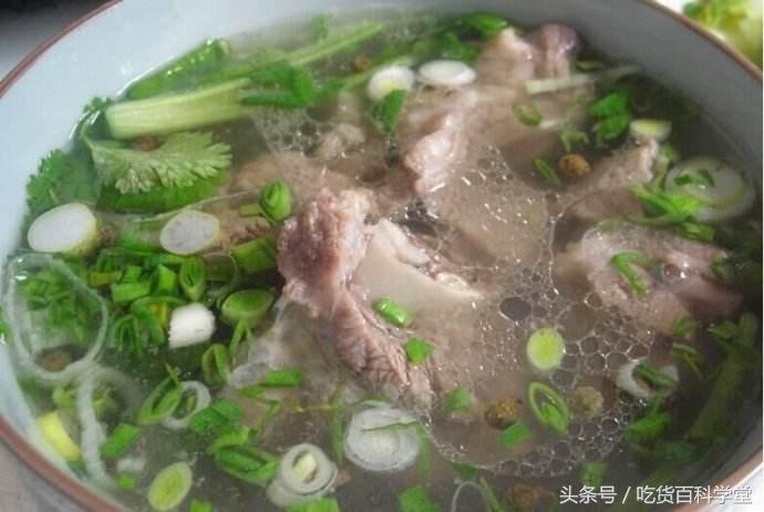 高清俯拍:乳白色浓汤表面浮着半透明粉葛片与酥软猪骨块,汤色清亮微带淡黄,可见细小胶质絮状物悬浮,无浮油,配青葱末点缀,盛于青花瓷深汤碗中 粉葛煲猪骨成品汤品特写