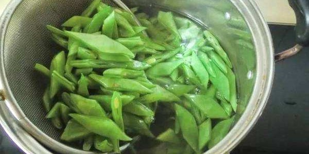 厨房中正在焯水的豆角