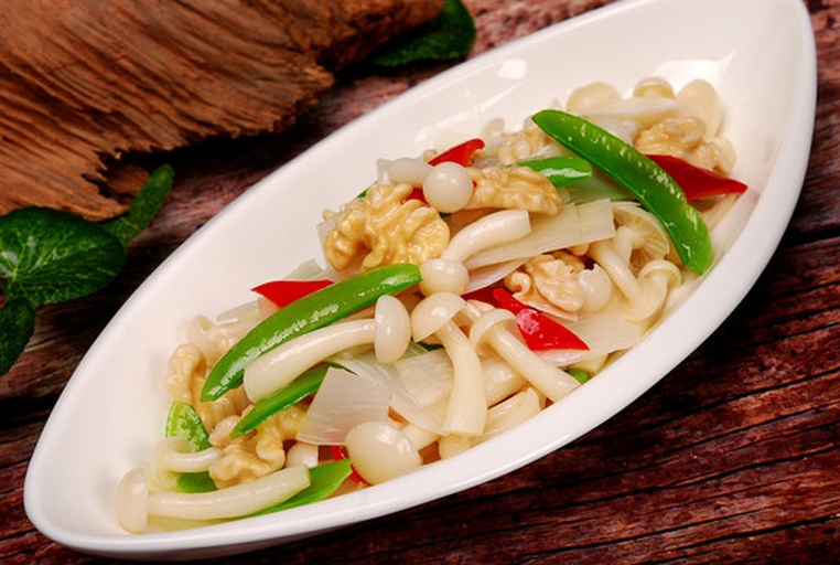 一盘刚出锅的白玉菇炒土豆盛放在浅灰色圆形瓷盘中,土豆呈金黄色,白玉菇洁白柔韧,点缀着翠绿葱花和青椒,菜肴表面微微带汁光亮,背景为简约北欧风格餐桌 成品装盘展示图