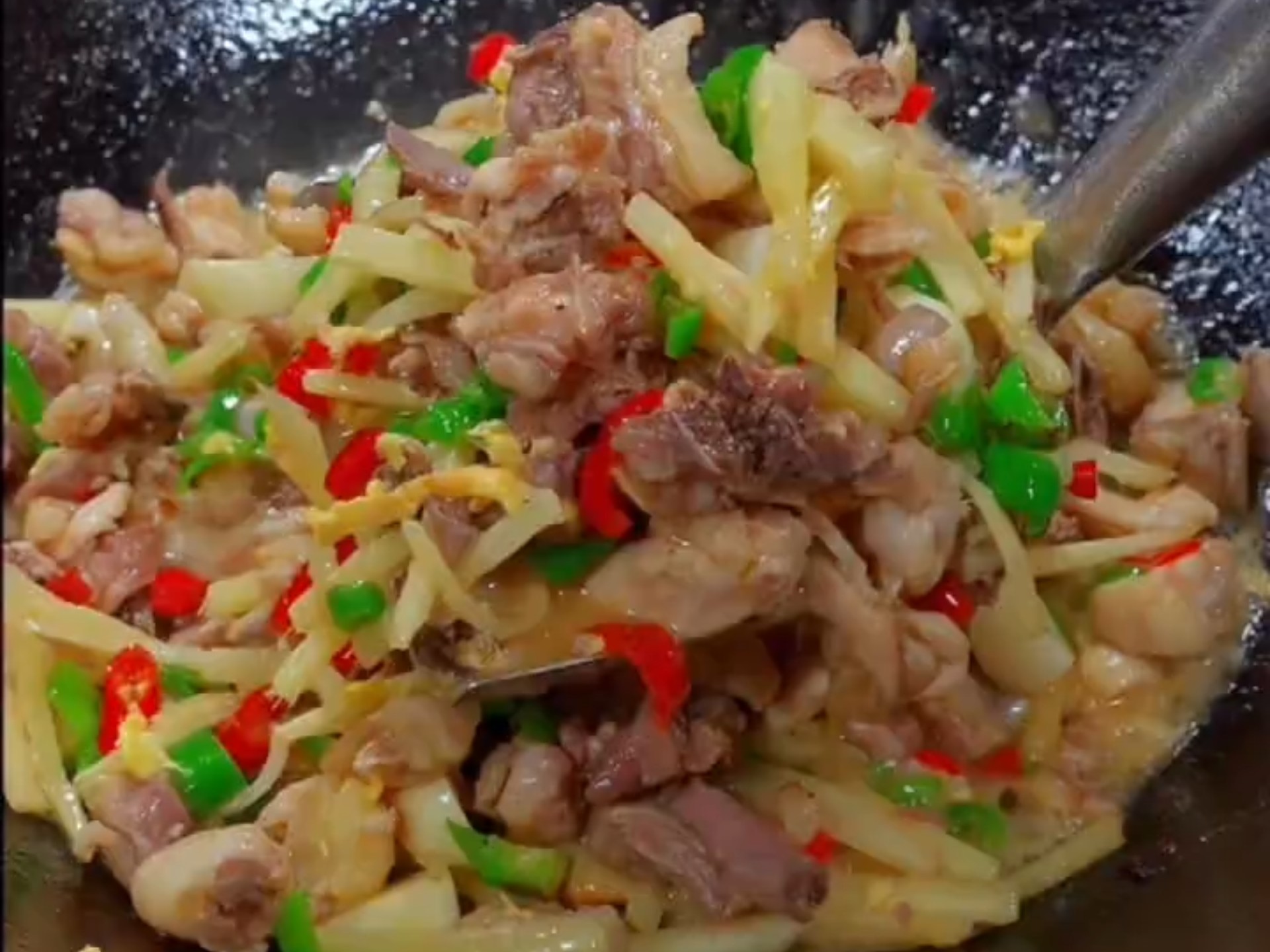 展示泡椒蓉用于炒菜的烹饪过程,锅中翻炒的鸡肉与泡椒蓉混合,散发出诱人香气 泡椒蓉烹饪应用图