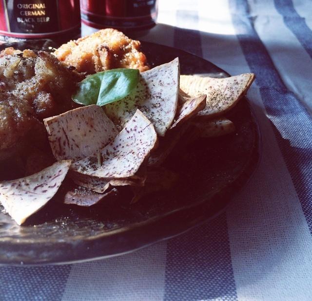 一家四口在明亮的餐厅里围桌吃饭,桌上有一大盘煮好的芋头,孩子正用筷子夹起一块,父母微笑看着,氛围温暖和谐,体现家庭饮食健康理念 一家人围坐在餐桌前享用煮芋头