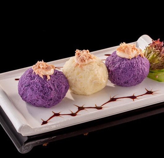 一张木质托盘上放置三个小碗,分别盛有金黄色的咸蛋黄肉松混合物、橙红色的咖喱鸡肉泥、以及白色带拉丝的芝士混合物,每个碗旁各有一个已包好的生土豆球切面图,清晰显示内部馅料结构 不同口味内馅的对比展示