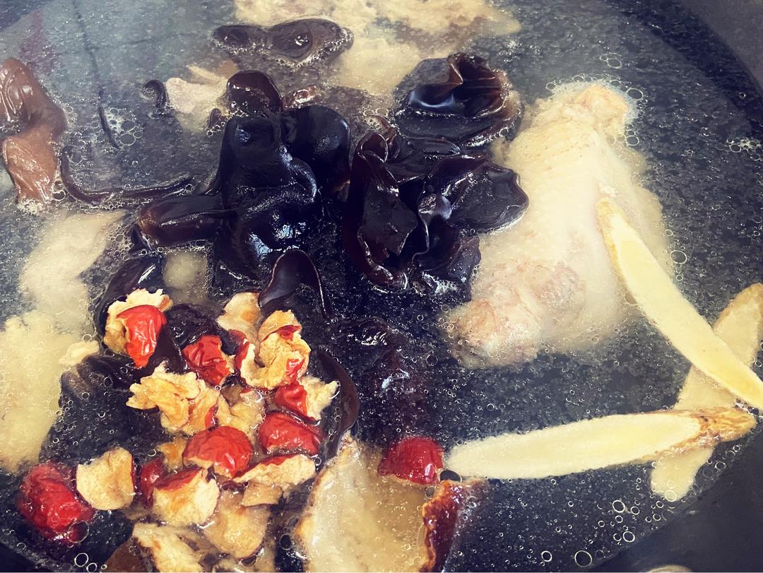 图片说明:一碗热气腾腾的柴胡散炖鸡汤特写,汤色清亮呈琥珀黄色,鸡肉块分布均匀,表面漂浮着几片姜和一颗红枣,旁边摆放木勺与青瓷碗,背景虚化为厨房暖光环境,传递温馨养生氛围 柴胡散炖鸡汤成品图