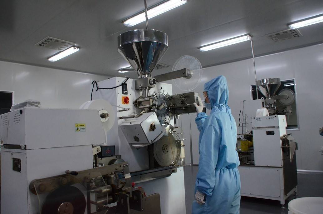 展示工人穿戴防护装备,在容器中配制乙烯利溶液,另一人将青皮核桃浸入药液,旁边放置温度计和pH试纸,背景为标准化处理车间 化学药剂处理流程示意图