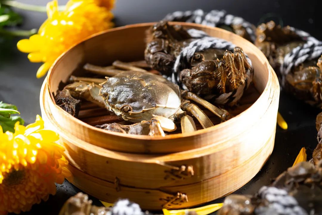 一个传统竹制蒸笼放置在沸腾的锅上,工人正在掀开盖子查看野菊花的蒸制情况,笼内可见黄色小花整齐铺放,蒸汽升腾,展示实际操作场景 野菊花蒸制过程示意图