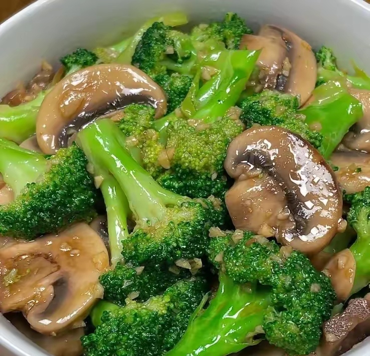 西兰花与蘑菇清炒过程中的锅具特写