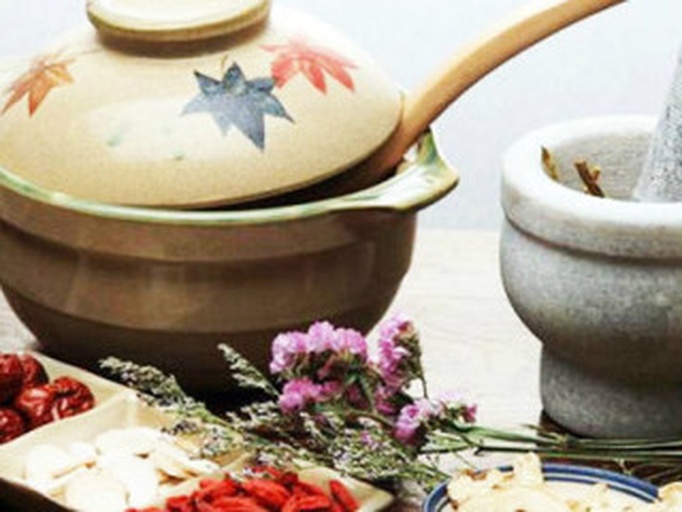 俯拍图:深蓝色棉麻布巾上摆放白胡椒粒、生姜片、肉桂枝、红枣、研钵,背景模糊的中药柜,体现传统中医养生场景 白胡椒与其他中药材搭配摆放于中医诊脉布巾上