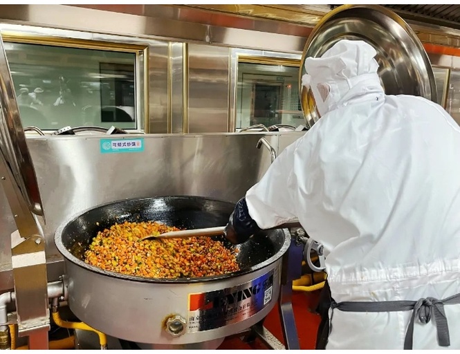 一位穿着白色围裙的厨师站在现代厨房中,手持炒锅正在进行翻炒动作,锅内可见浅褐色山药条与金黄蒜末混合,火焰适中,背景整洁明亮 厨师正在灶台上翻炒锅中山药条