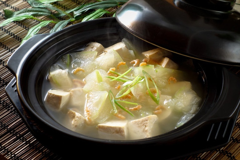 不锈钢锅中炖煮中的冬瓜豆腐汤,汤体清亮,食材完整,体现家庭烹饪场景 一锅正在炉灶上炖煮的冬瓜豆腐汤,汤色清澈,可见冬瓜片与豆腐块,蒸汽升腾