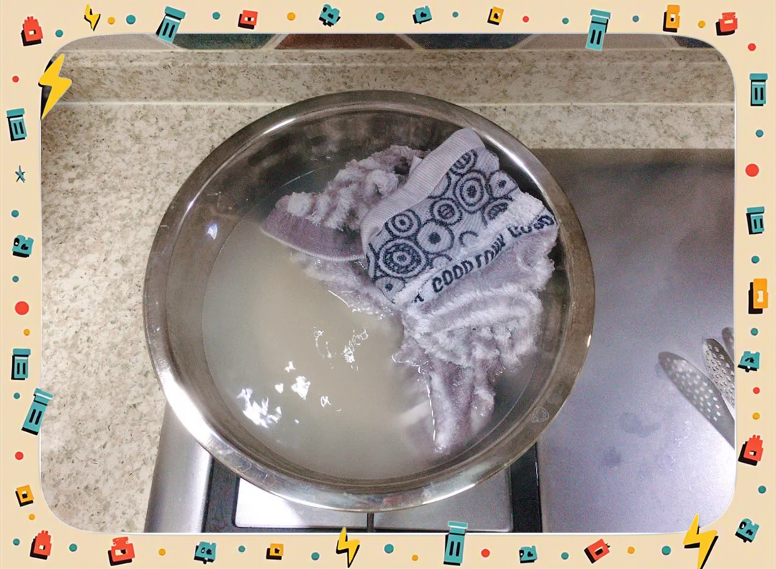 一名厨师戴着手套,正在将一盘刚从沸水中捞出的透明藕片倒入一个盛有大量冰块和水的不锈钢盆中,水面泛起白烟,显示温差剧烈,操作台整洁,背景为专业厨房环境 厨师正在将焯水后的藕片倒入装满冰块的盆中进行冷却处理