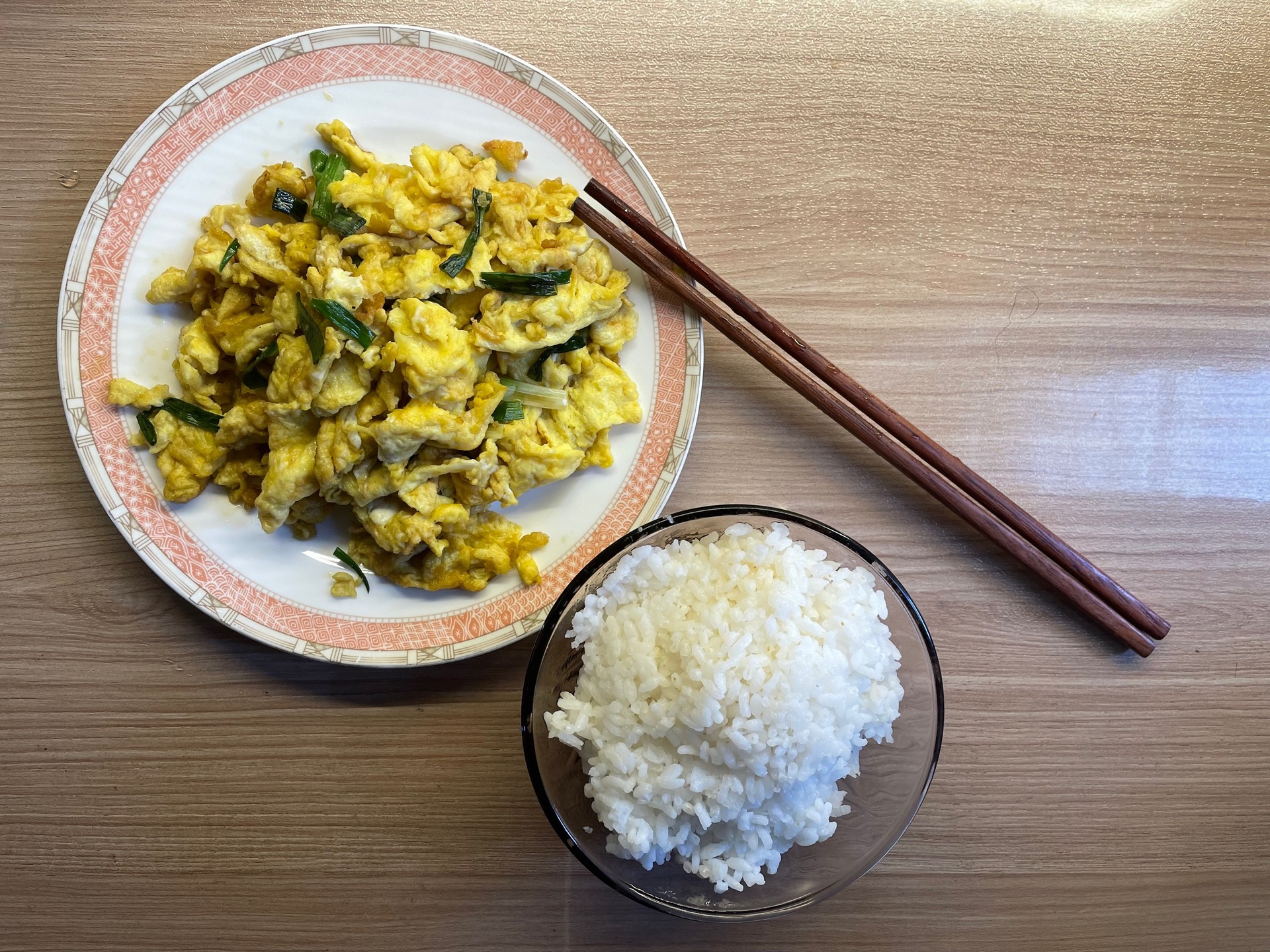 一张木质餐桌上摆放着一盘蒸熟的乳白色糯玉米,旁边配有西兰花、煎蛋和小米粥,一家人正在温馨用餐,窗外透进早晨阳光,营造健康早餐氛围 家庭餐桌上的糯玉米