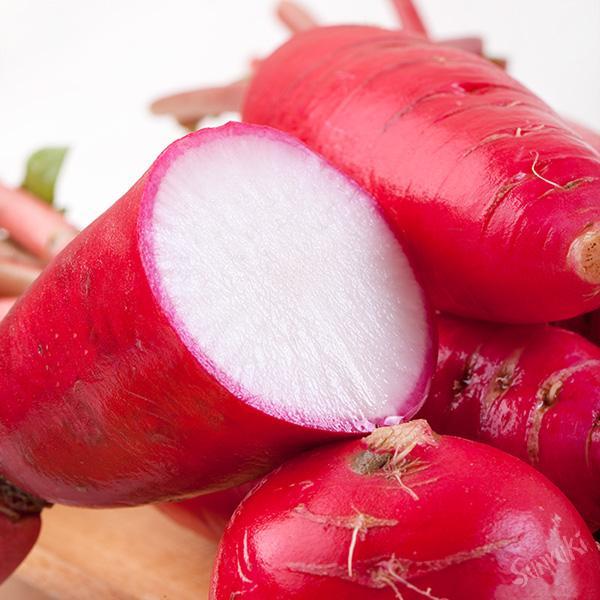 一个刚被横向切开的红皮萝卜,露出洁白的内部组织,外圈为一圈薄薄的鲜红色表皮,切面湿润有光泽,旁边摆放一把不锈钢小刀,背景为浅灰色大理石台面,强调干净卫生的食材处理环境 红皮萝卜切面展示图