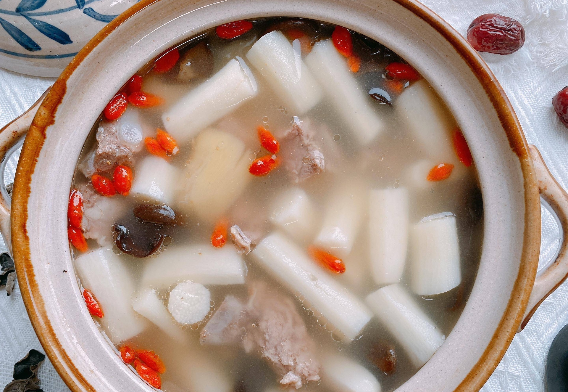 全景俯拍:青白相间的清汤中悬浮着12颗饱满圆润的萝卜肉圆,表面光滑微泛油光,可见细小气孔;汤色澄澈见底,点缀翠绿葱花与橙红枸杞,热气氤氲,肉圆形态完整无裂痕 刚出锅的萝卜肉圆汤成品图