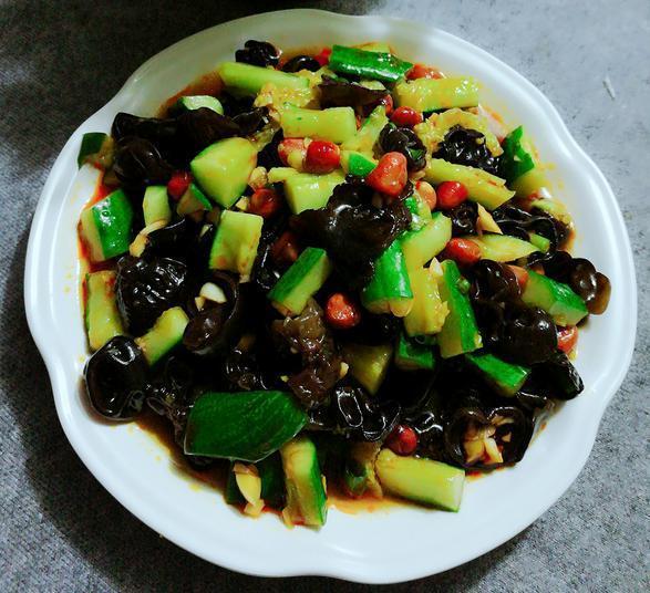 凉拌木瓜丝成品摆盘：晶莹剔透的青木瓜丝堆叠成小山状，淋着琥珀色酱汁，表面撒金黄烤花生碎与翠绿薄荷叶，背景为竹编托盘与青柠角装饰