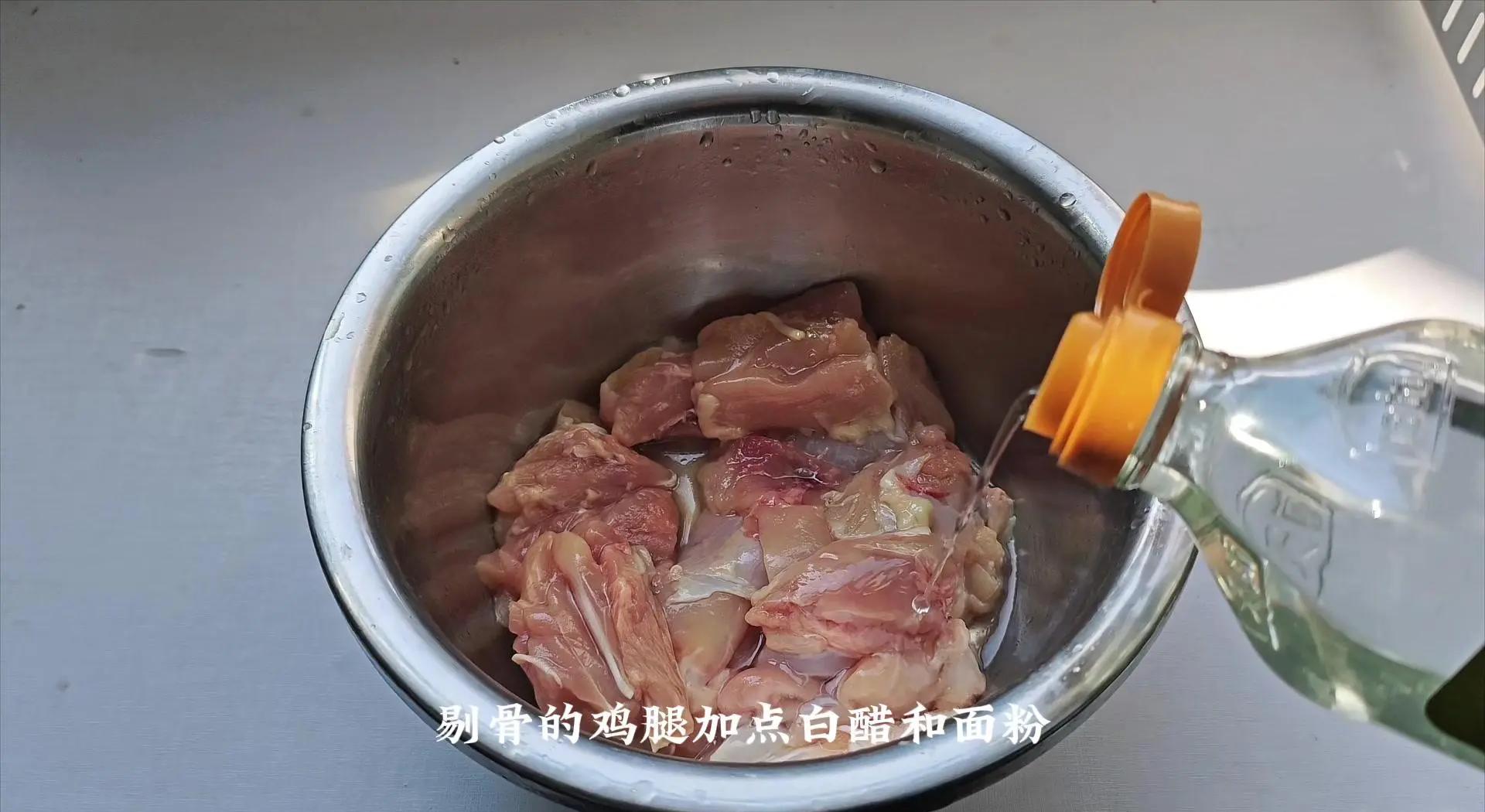 一只手正在将腌好的鸡腿放入装有白色粉末的盘中,另一只手轻拍使其均匀裹粉,旁边有打散的鸡蛋液和调料碗,操作台整洁明亮,展示清晰的裹粉步骤 鸡腿裹粉过程特写