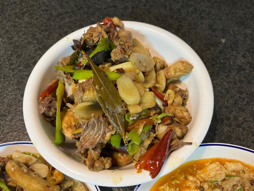 一碗热腾腾的风姜鸡汤,汤色清澈,香气扑鼻,旁边放着风姜片和鸡块 风姜鸡汤成品图