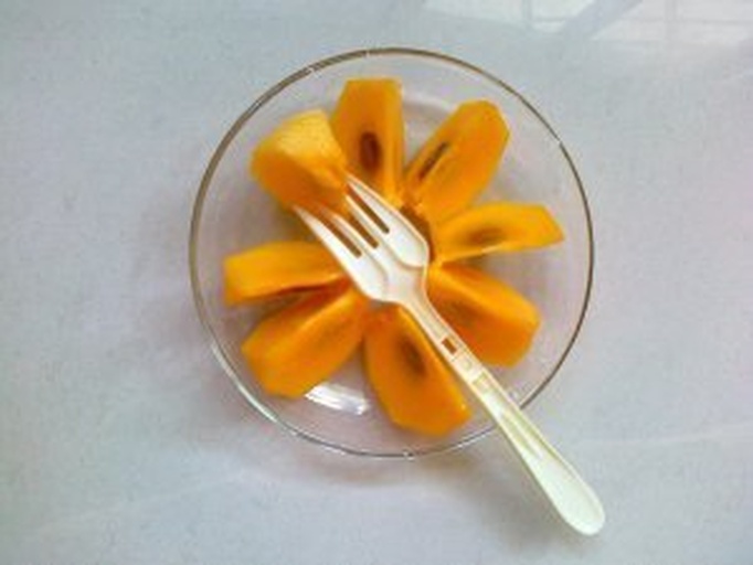 案板上摆放着多个手工压扁的脆柿子饼生坯,边缘整齐,表面微撒干粉,背景为木色料理台与不锈钢碗 脆柿子饼生坯整形过程