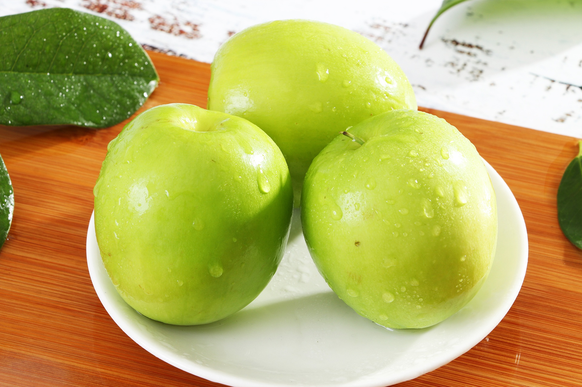 特写镜头:不锈钢冷榨机进料口投入翠绿黄瓜条与青苹果块,机器外壳凝结细密水珠,下方玻璃壶接取清澈翠绿色汁液,强调低温冷榨工艺 黄瓜汁冷榨操作特写