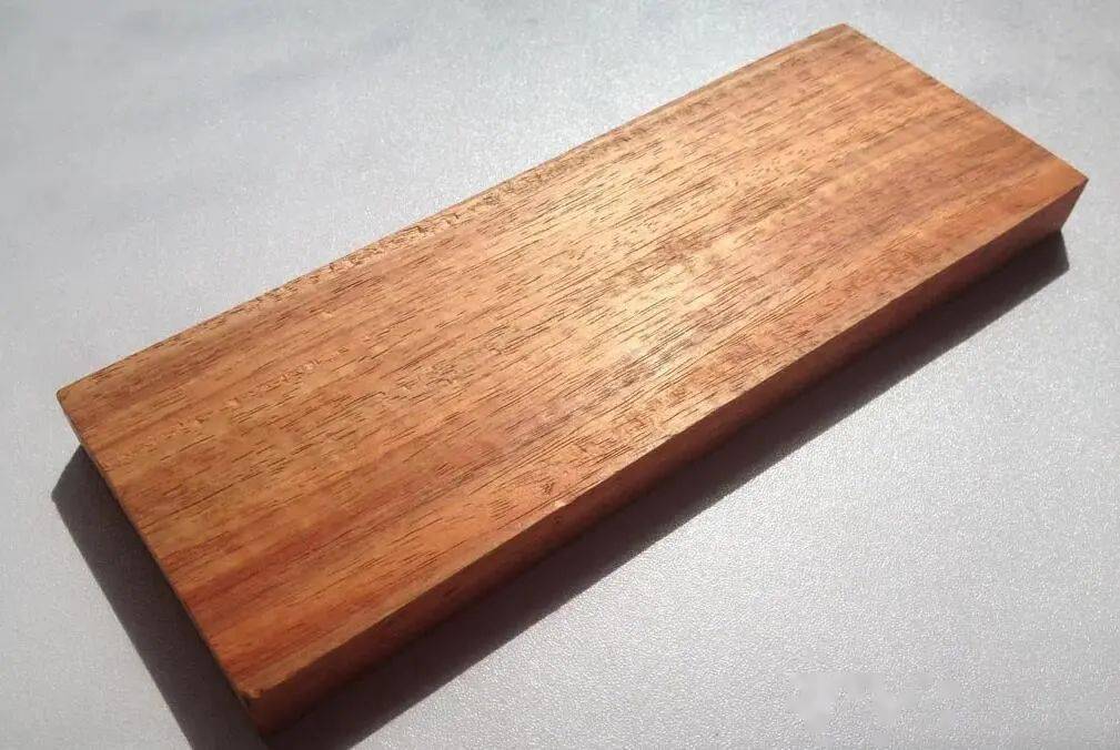 展示一块完整的金花梨原木,纹理清晰可见,色泽金黄,木质表面光滑 金花梨原木展示