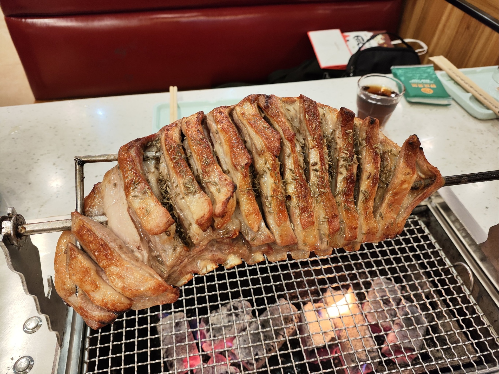 烤羊白条正在炭火上慢烤过程图