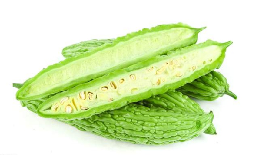 新鲜苦瓜剖开后的内部结构细节展示,突出其植物学特征和可食用部分 苦瓜横切面特写,清晰可见内部红色假种皮包裹黑色种子,翠绿色果肉质地细腻,表面有规则瘤状突起