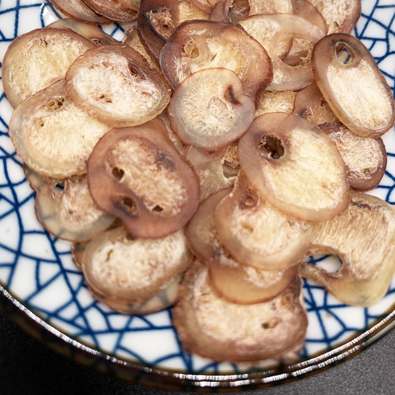 一张长方形白色瓷盘中盛放着清炒白莲藕片,藕片整齐排列呈半圆形,颜色洁白透亮,点缀少许红色辣椒丝和绿色葱花,背景为简约厨房台面,整体构图干净明亮,展现‘藕白色’在美食中的美学应用 白莲藕烹饪摆盘场景