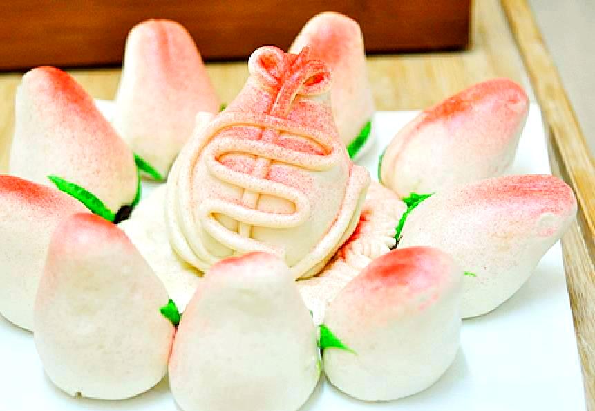 手工寿桃包制与上色过程,展示如何包入馅料并捏成桃形,以及最后点红上色的细节 手工寿桃包制与上色过程展示