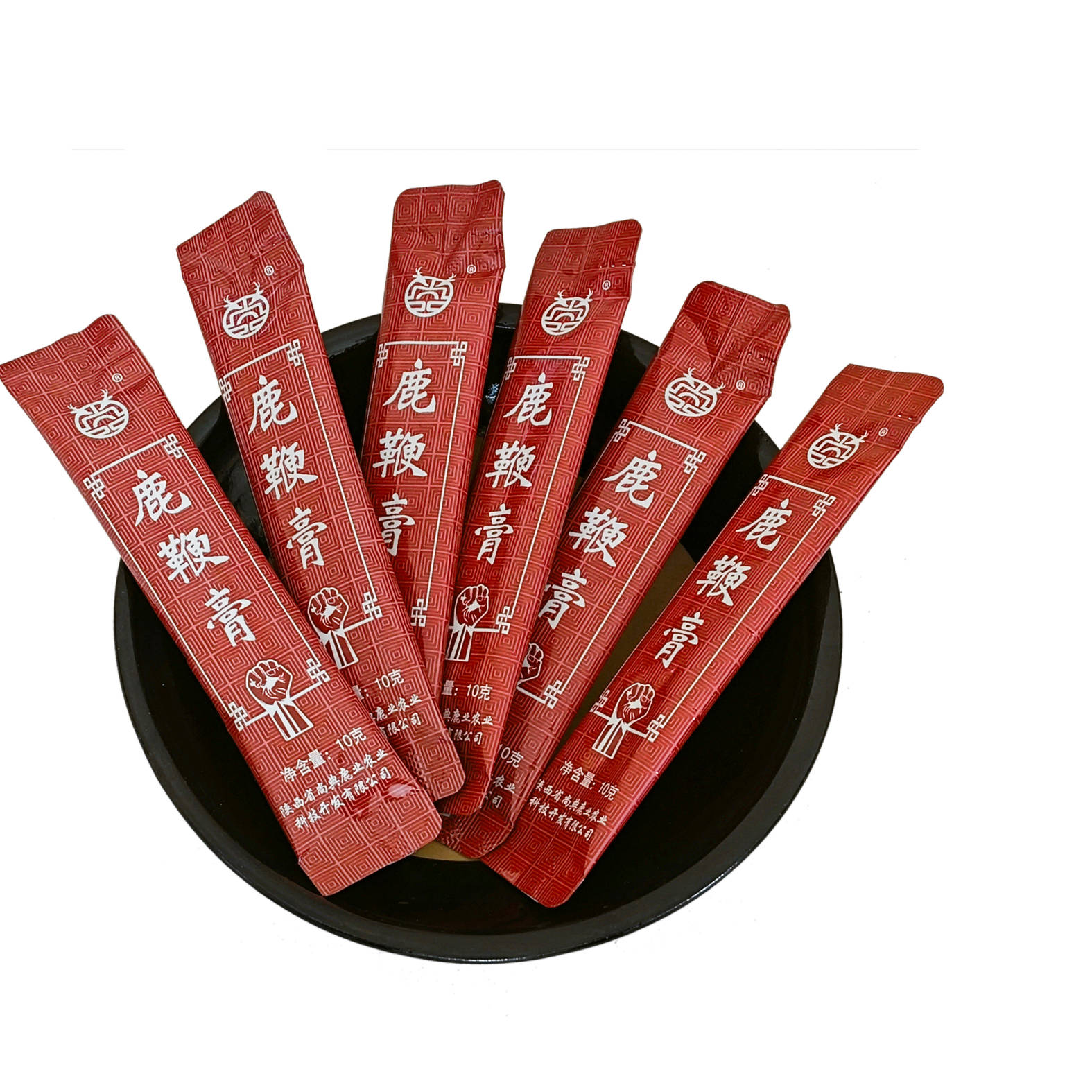 展示一块块独立包装的鹿鞭膏成品,背景为中药材与熬制工艺场景 鹿鞭膏成品展示