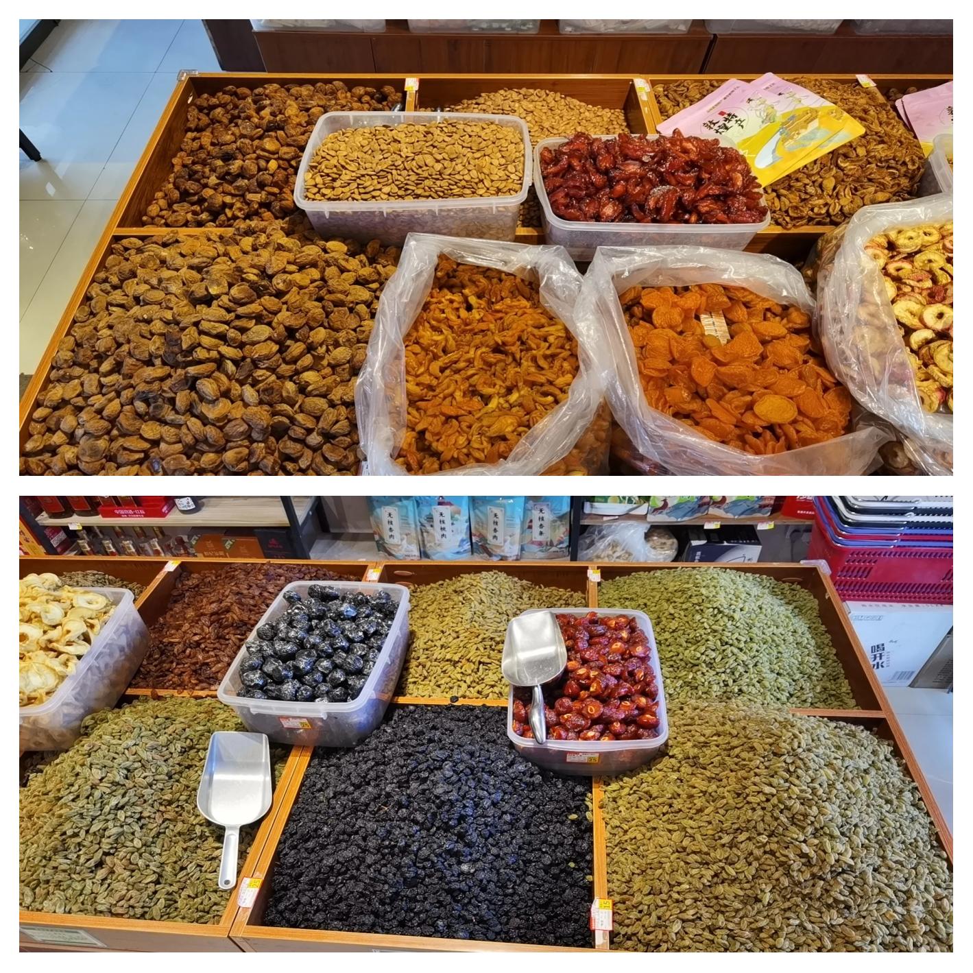 一个传统农贸市场中的干果摊位,陈列着多种类型的干枣,包括红色的大枣、深褐色的黑枣以及小颗粒的金丝小枣,摊主正在整理货品,背景有顾客驻足挑选,体现真实购物场景 市集上售卖各类干枣的摊位