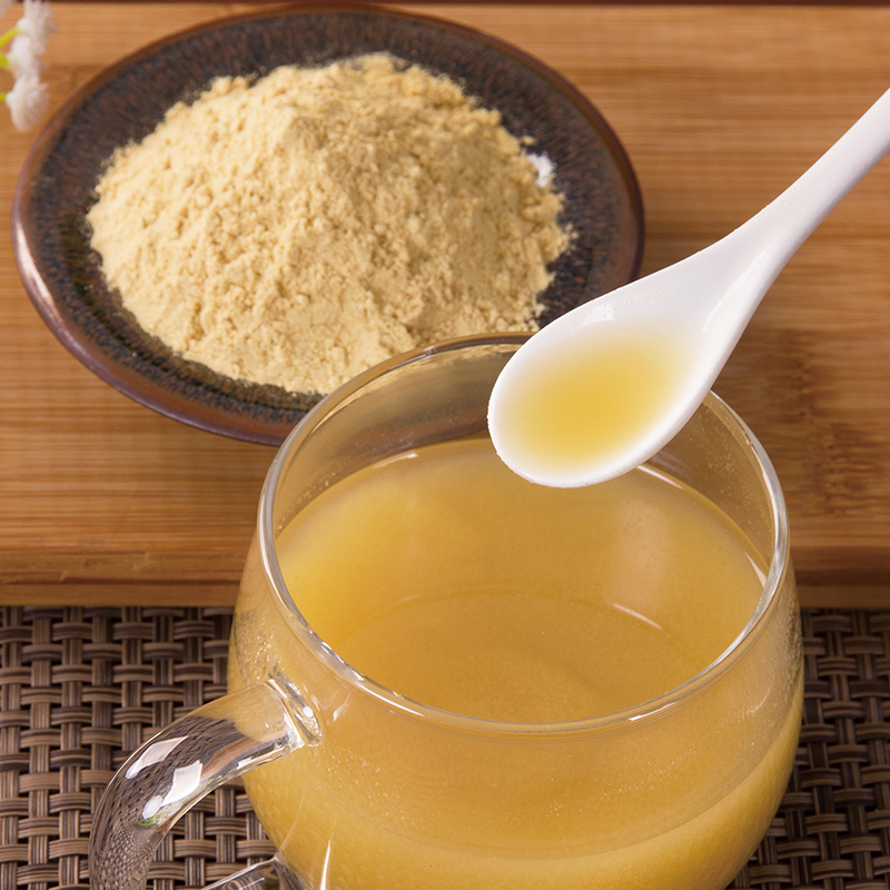 展示黑玛卡粉冲泡在牛奶或果汁中的饮品图,背景为厨房或办公环境 黑玛卡粉冲泡饮品图