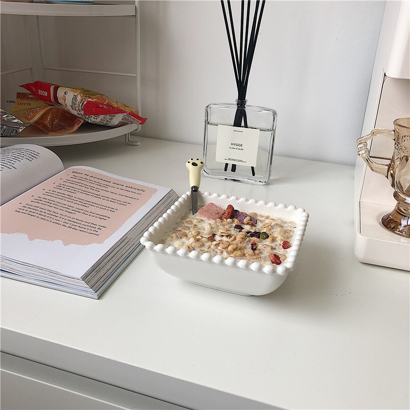 一张清晨餐桌俯拍图,白色瓷碗中盛有燕麦牛奶粥,表面撒有切碎的核桃仁、蓝莓和香蕉片,旁边放有一把木勺和一杯橙汁,背景柔和自然光,体现健康生活方式场景 核桃与早餐搭配场景