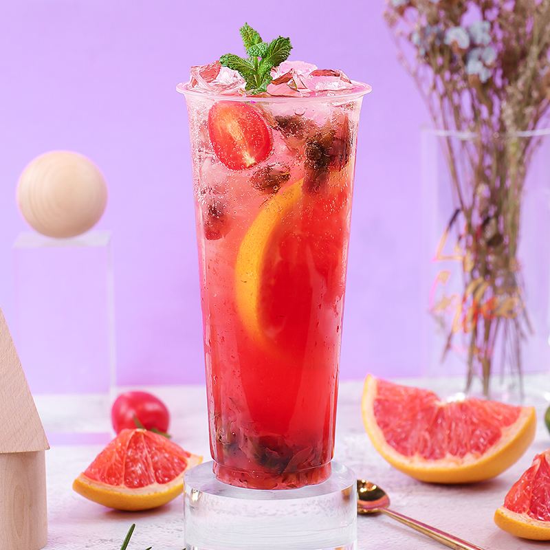 一杯冰镇葡萄柚红茶,杯壁凝露,葡萄柚切片点缀,背景为夏日餐桌 葡萄柚红茶成品图