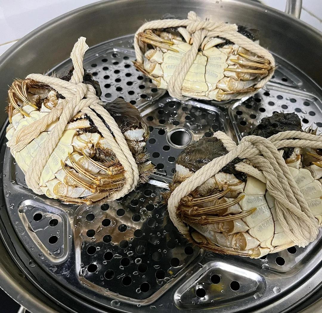 专业蒸制场景:精准控制的微沸状态,保鲜膜孔洞清晰可见,体现‘蟹眼泡’火候标准 蒸制过程示意图:不锈钢蒸锅内,白色瓷盅覆带孔保鲜膜,水面平静泛微泡,无剧烈翻滚