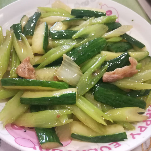 三色鲜蔬切配特写：翠绿黄瓜片、橙红胡萝卜丝、浅绿带茎芹菜段整齐分列于不锈钢砧板上，背景为自然光厨房台面