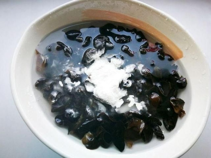 生活化实拍:家庭厨房内规范黑木耳冷水浸泡起始步骤,突出‘凉白开’‘不锈钢容器’‘适量清水覆盖’三大安全要素,手部清洁、动作轻柔 家庭厨房场景:不锈钢盆中盛放适量干黑木耳,旁边放置玻璃量杯装凉白开,手部特写正缓慢倾倒清水覆盖木耳,桌面整洁,背景虚化体现专业操作环境