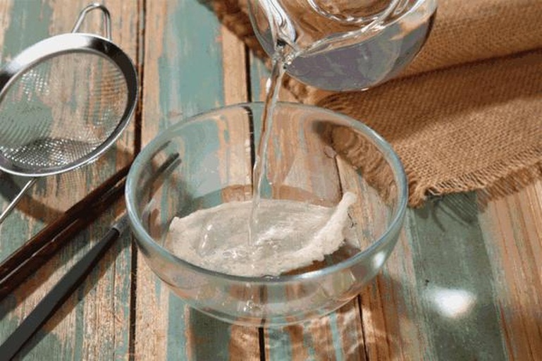 左侧为干燕盏,中间为泡发4小时后的蓬松状态,右侧为撕条并挑毛完成的洁净燕丝,背景为白色瓷盘与不锈钢镊子,展示清晰操作步骤 燕窝泡发过程三联图