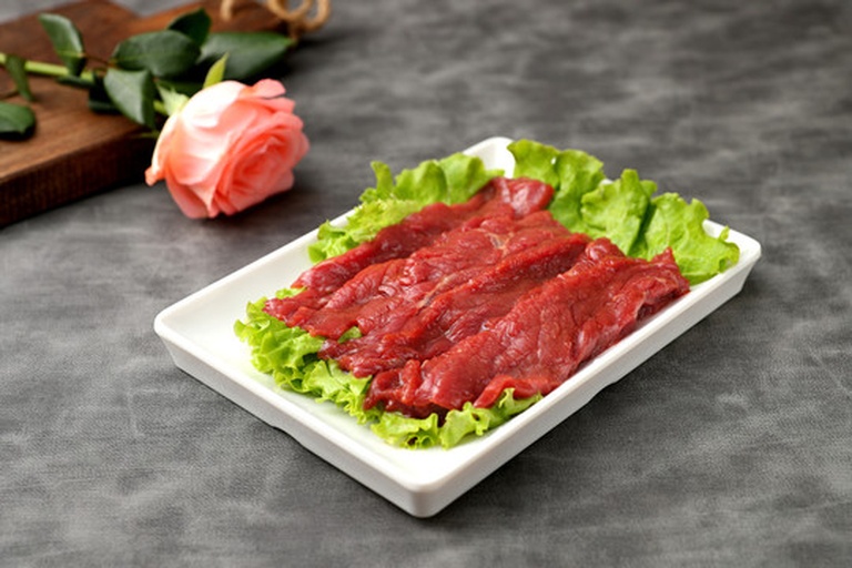 平视特写:6个翠绿生菜卷整齐排列于浅灰石板上,每个卷切为两段露出红黄白三色内馅(番茄丁、鸡丝、牛油果),表面淋微量芝麻酱与白芝麻,背景虚化为阳光窗台 番茄生菜手撕卷成品摆盘