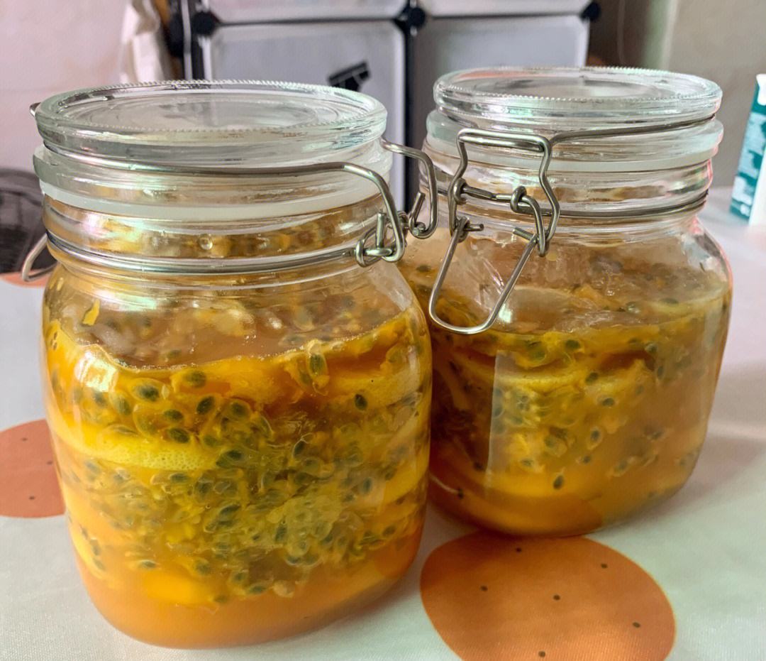 玻璃密封罐内盛放已处理好的金桔与百香果混合物,标签注明‘果茶浓缩液’,展示预加工存储方案 透明密封罐中装有切好的金桔与百香果混合物,罐外标注“果茶浓缩液”,旁边放有量勺和玻璃瓶