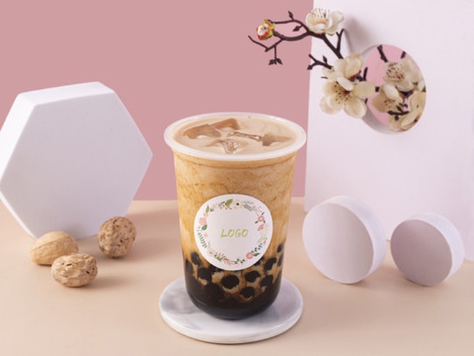 生活化美食摄影:突出饮品澄澈色泽、杯壁冷凝水珠(证明刚冲泡完成)、真实食用配件,强化家庭可操作性与感官信任感 家庭场景烤枣泡水成品图:素雅白瓷杯中盛放清澈微金黄色烤枣水,杯壁凝结细密水珠,杯底沉降少量柔韧枣肉纤维,旁置两颗完整烤枣与不锈钢滤网勺,背景为木质料理台与鲜枣枝条