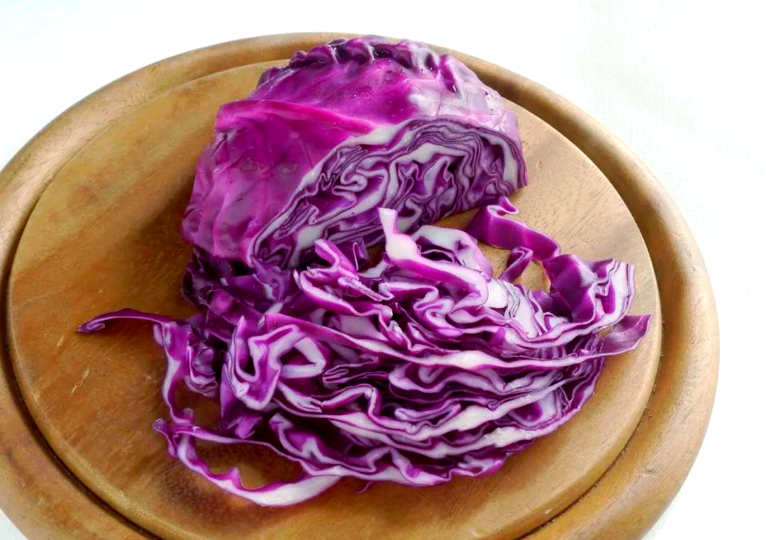 厨房中切开的紫甘蓝与散叶紫菜对比