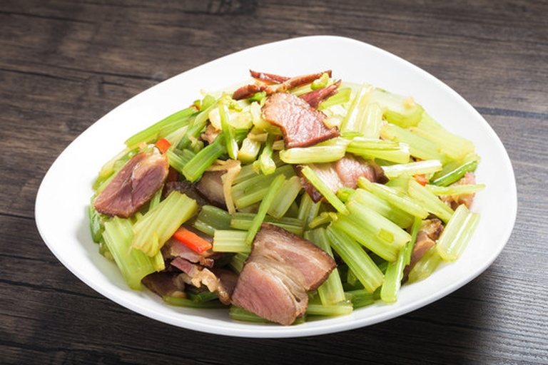 一碗白米饭上覆盖着满满的山芹肉丝，旁边配有竹筷和小碟泡菜，整体呈现温馨家常氛围