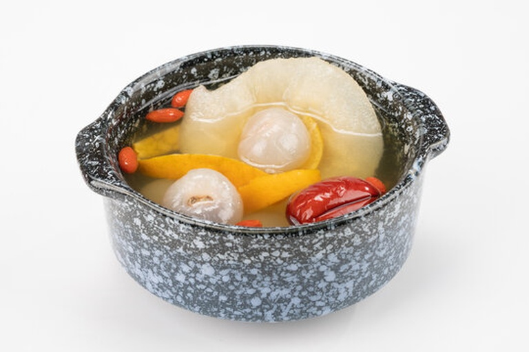 一碗热腾腾的荔枝雪梨煮水,汤色清澈,荔枝果肉与雪梨块清晰可见,散发出清甜香气 荔枝雪梨煮水成品展示