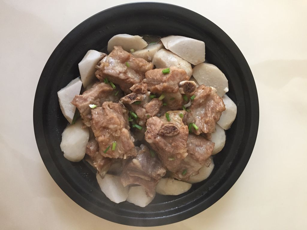 高清摆盘图:青花瓷深盘中,酱红油亮的排骨与晶莹琥珀色白萝卜错落堆叠,表面淋少许浓稠酱汁,点缀翠绿葱花与红椒丝,盘底有微量琥珀色汤汁反光,背景为浅灰麻布,光影柔和突出食物光泽与层次 成品红烧排骨炖白萝卜装盘特写