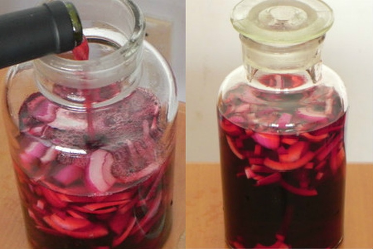 干红泡洋葱7日成品状态,突出酒液澄澈度、洋葱片透亮度及紫红渐变色泽,体现工艺成功 干红泡洋葱成品特写:晶莹剔透的紫红色洋葱片悬浮于深宝石红色酒液中,可见清晰纹理与微微反光,盛于透明玻璃罐内,罐身凝结细小水珠