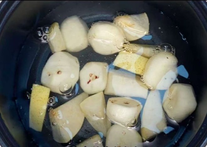 砂锅中鲫鱼正在沸腾的汤水中翻滚，汤色已呈乳白色，锅边可见密集气泡，上方有蒸汽升腾
