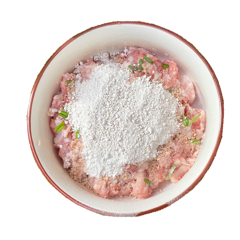 一位厨师正在白色厨房环境中搅拌羊肉馅,碗中肉馅已起胶发亮,周围有序排列生姜末、葱花、酱油瓶、香油瓶等调味品 厨师正在用手沿同一方向搅拌大碗中的羊肉馅料,动作有力,馅料呈现胶状质地,桌面上摆放着各种调料瓶