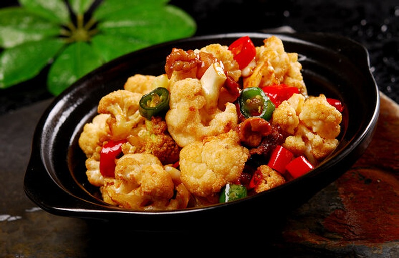干煸松花菜成品特写：金边微卷的松花菜花球堆叠饱满，红亮油光均匀包裹，点缀翠绿蒜苗与橙红辣椒段