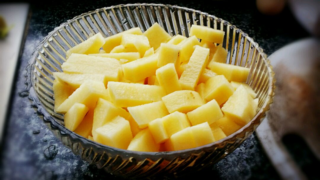 玻璃碗中盛装新鲜泰式菠萝莎莎:金黄菠萝块与鲜红小米辣、紫红洋葱丁、翠绿香菜叶形成高对比色;表面淋有晶莹青柠汁液,反射冷光;背景为浅木纹料理台,凸显清爽夏日感 泰式菠萝莎莎成品特写